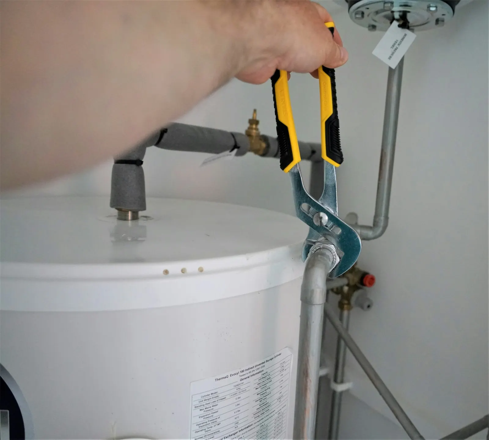 A wrench on the pipe fitting above a water heater